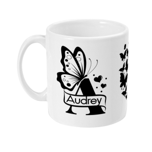 Personalised white ceramic mug with letter A monogram surrounded by butterflies and hearts, featuring the name 'Audrey' in a decorative banner.