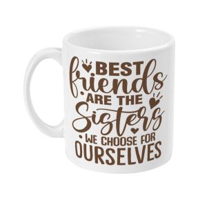 White ceramic mug with brown text design 'Best friends are the sisters we choose for ourselves' and decorative hearts and swirl motifs.