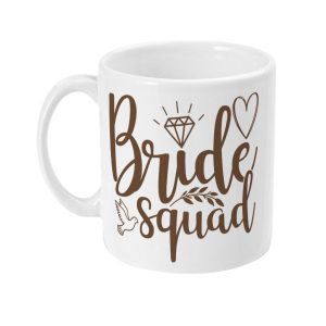White ceramic mug with 'Bride Squad' in brown script surrounded by decorative elements like hearts and leaves.