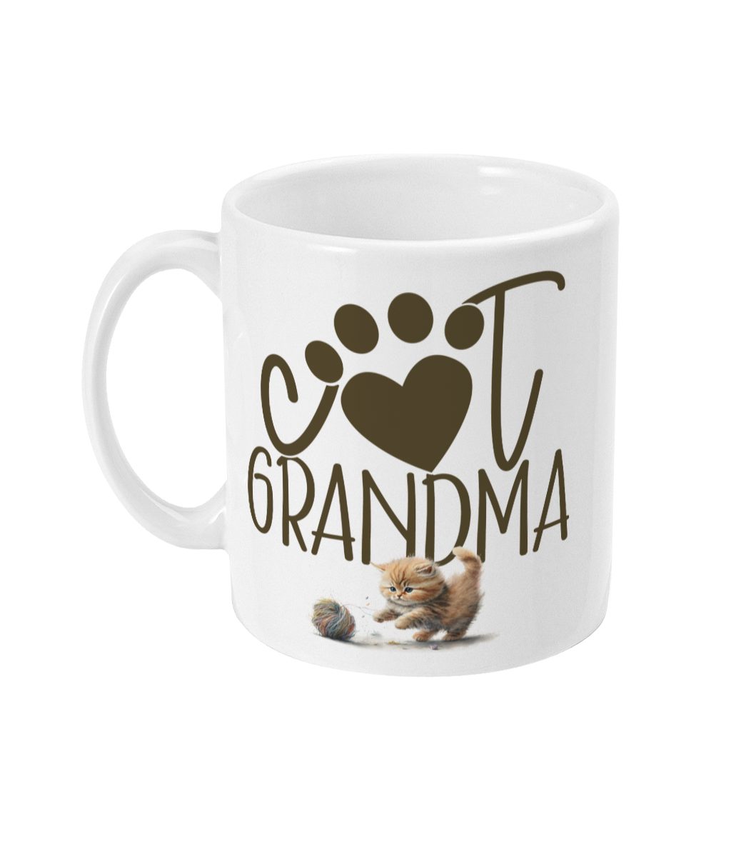 White ceramic mug with 'I ♥ U GRANDMA' text in brown and playful orange kitten with a ball of yarn