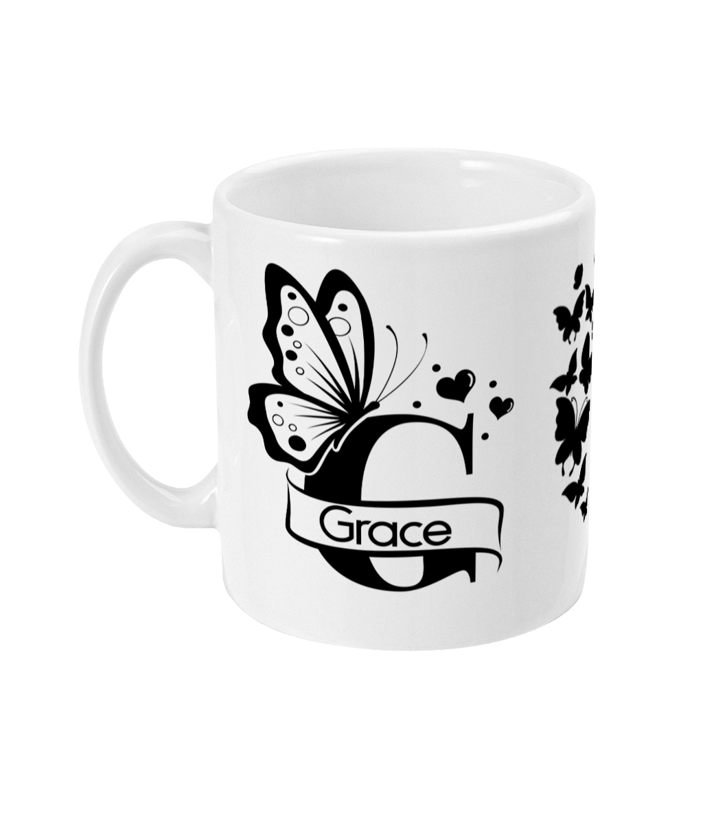 White ceramic mug featuring a butterfly and floral design with the word 'Grace' in a decorative banner motif.