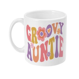 White mug with colorful 'GROOVY AUNTIE' text in pink, purple, orange, and yellow, adorned with flowers and hearts.