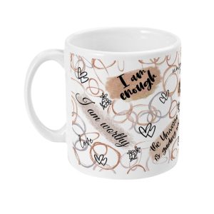 White ceramic mug with affirmations 'I am enough' and 'I am worthy', adorned with delicate gold hearts and floral motifs.
