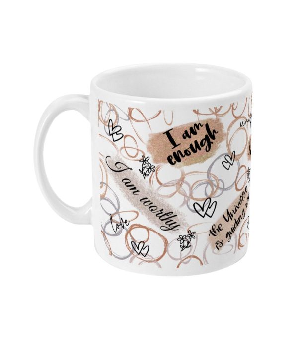 White ceramic mug with affirmations 'I am enough' and 'I am worthy', adorned with delicate gold hearts and floral motifs.
