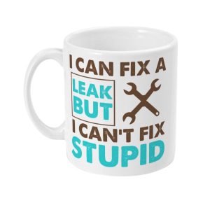 White mug with text 'I CAN FIX A LEAK BUT I CAN'T FIX STUPID,' accompanied by crossed wrench and hammer graphics.