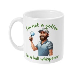 White ceramic mug featuring a man with a golf ball and witty text 'I'm not a golfer. I'm a ball whisperer'.