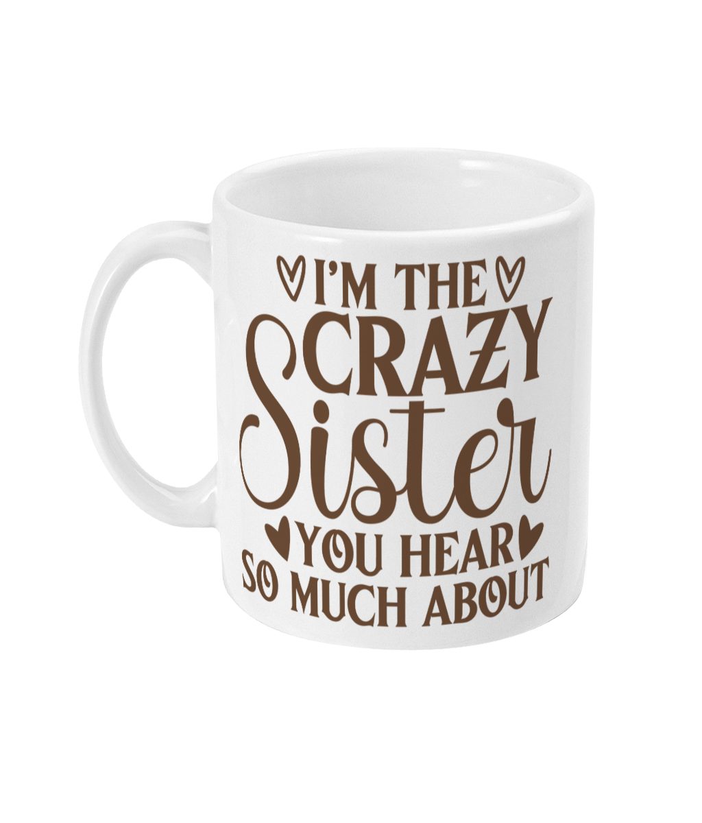 White ceramic mug with bold brown text 'I'm the CRAZY SISTER you hear SO MUCH ABOUT' and heart decorations.