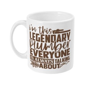 White ceramic mug with text 'I'm this LEGENDARY PLUMBER EVERYONE IS ALWAYS TALKING ABOUT', featuring a pipe wrench and stylized feathers design.