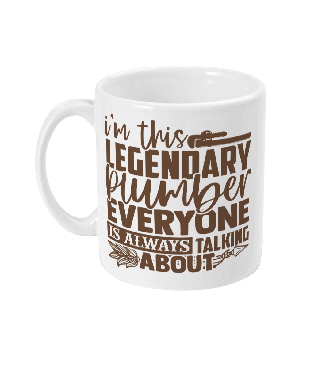 White ceramic mug with text 'I'm this LEGENDARY PLUMBER EVERYONE IS ALWAYS TALKING ABOUT', featuring a pipe wrench and stylized feathers design.