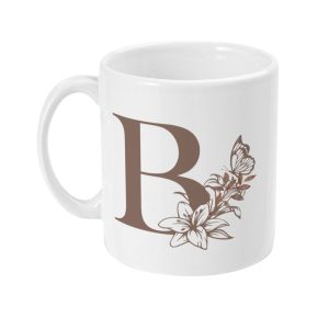 White ceramic mug with dark brown letter 'R' surrounded by elegant flowers and a butterfly design.