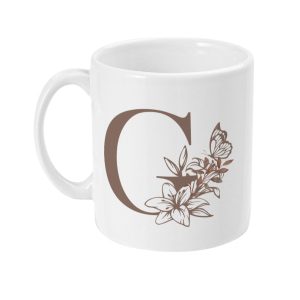 White ceramic mug with floral initial 'G' design and butterfly in brown tones