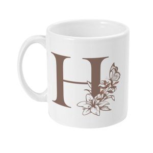 White ceramic mug with large brown letter 'H' surrounded by floral graphics