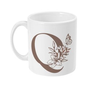 White ceramic mug with brown stylized letter Q, adorned with floral elements and a butterfly. Handle on the left side.