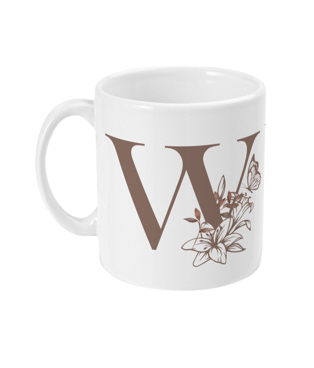 White ceramic mug with a stylized letter W and floral design in brown