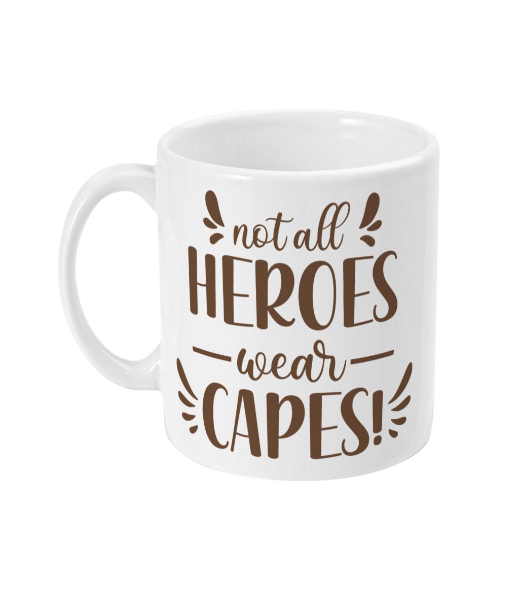 White mug with brown and dark brown text 'Not all HEROES wear CAPES!' in decorative typography.