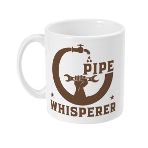 White ceramic mug featuring 'PIPE WHISPERER' text, pipe illustration with figure holding a wrench, dripping tap, and stars.