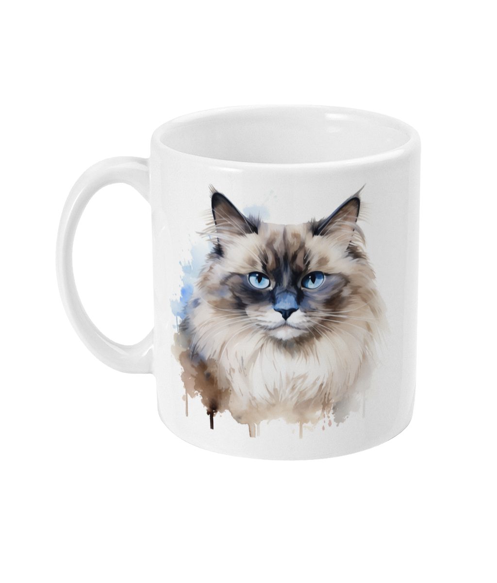 White ceramic mug featuring a watercolor-style graphic of a Ragdoll cat with blue eyes and artistic splashes of blue and brown around it.