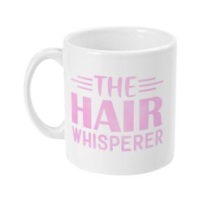 White ceramic mug with bold pink text 'THE HAIR WHISPERER' and stylized pink graphic elements