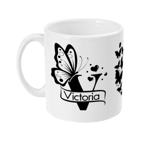 Monochrome ceramic mug featuring a large butterfly design, smaller butterflies, heart shapes, and the name 'Victoria' in a stylized banner.