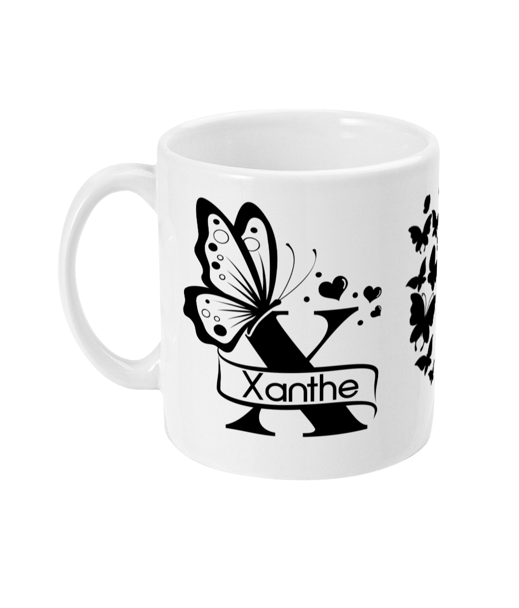 White mug with black butterfly and heart designs, featuring 'Xanthe' on a ribbon banner.