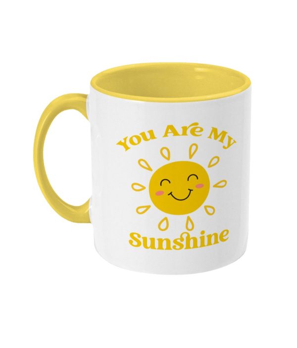 White mug with yellow interior and handle, featuring a smiling sun and 'You Are My Sunshine' phrase in yellow font.