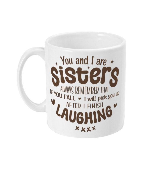 White ceramic mug with brown text saying 'You and I are sisters always remember that if you fall I will pick you up after I finish laughing,' adorned with hearts and X's.