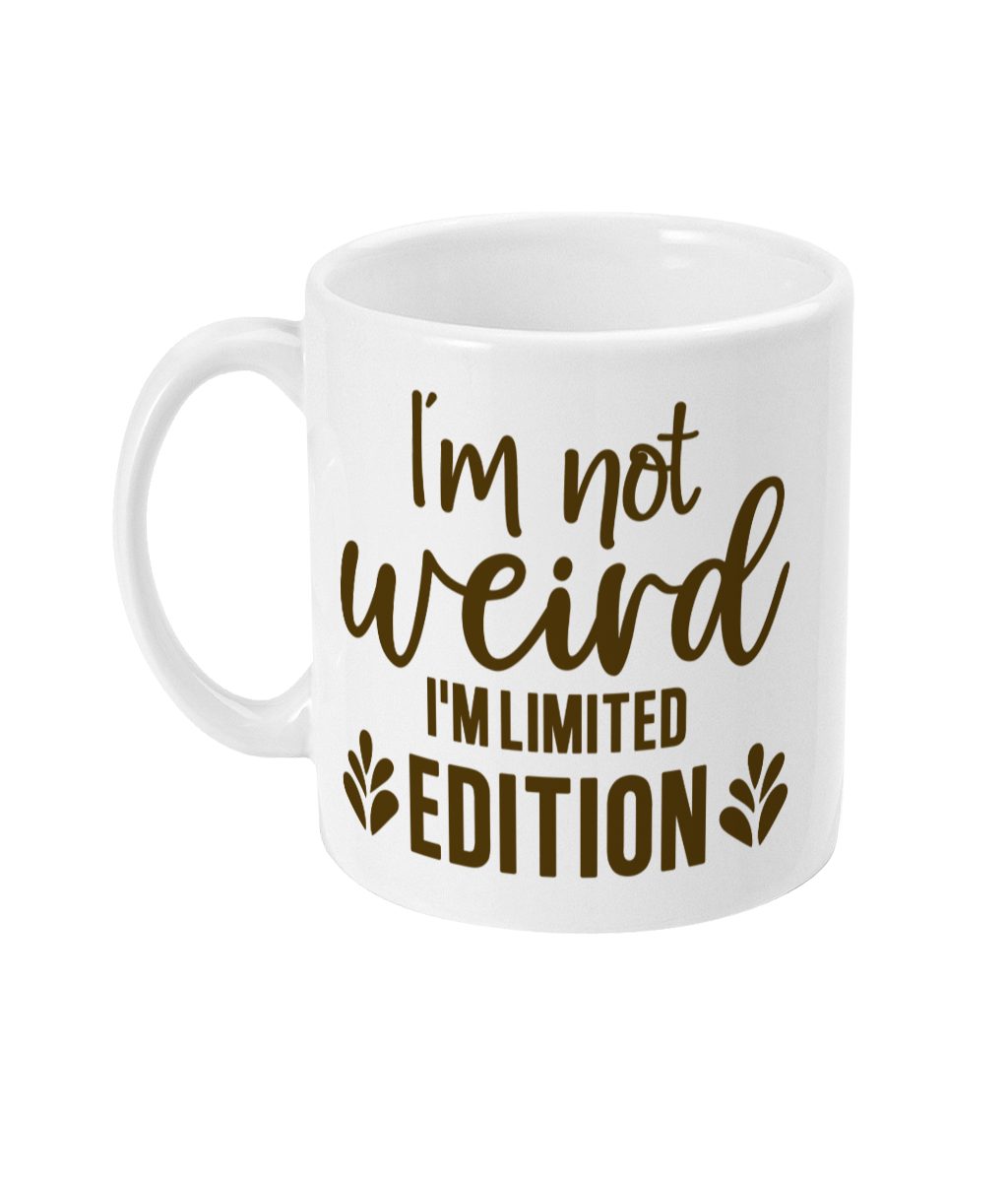 White ceramic mug with 'I'm not weird I'm LIMITED EDITION' text in dark brown script and leaf graphics.